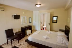 een slaapkamer met een bed, een bureau en een stoel bij Lorenzo House Apartments in Lassi