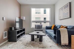 a living room with a blue couch and a tv at Blueground New Tacoma balcony nr Museum SEA-954 in Tacoma