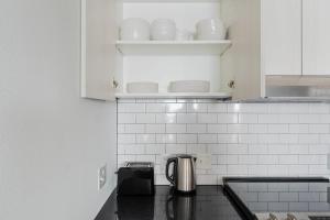 une cuisine avec des armoires blanches et un comptoir dans l'établissement Blueground New Tacoma balcony nr Wright Park SEA-956, à Tacoma 9 autres photos