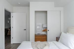 une chambre avec un lit blanc et un placard dans l'établissement Blueground New Tacoma balcony nr Wright Park SEA-956, à Tacoma