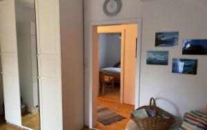 Un pasillo con un reloj en la pared y un dormitorio. en Haus Schartner Aloisia, en Altaussee