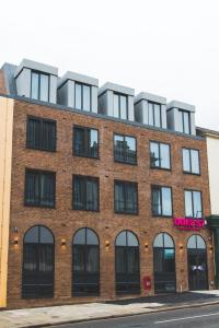 a red brick building with black windows on a street at Duke Street Boutique Hotel in Liverpool