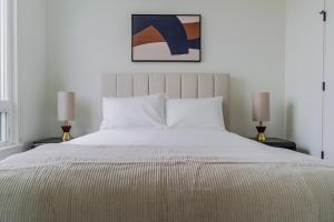 a bedroom with a large white bed with two lamps at Blueground Lynnwood view nr Lynndale Park SEA-950 in Lynnwood
