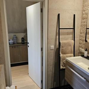 a bathroom with a white door and a sink at LA BELLE IDEE in Nokere +15 photos