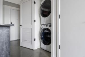 - une buanderie avec un lave-linge et un sèche-linge dans l'établissement Blueground New Tacoma balcony nr Union Station SEA-955, à Tacoma