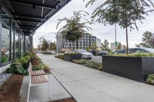 un banc sur un trottoir devant un bâtiment dans l'établissement Blueground New Tacoma balcony nr Union Station SEA-955, à Tacoma