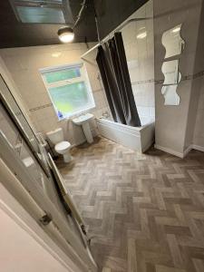 a bathroom with a toilet and a window at WOLVES Stay in Wolverhampton +9 photos