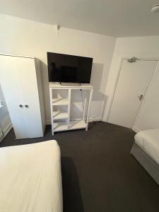 Un dormitorio con un televisor de pantalla plana sobre un mueble blanco. en WOLVES Stay, en Wolverhampton