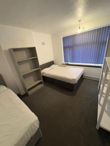 Un dormitorio con dos camas y una gran ventana. en WOLVES Stay, en Wolverhampton
