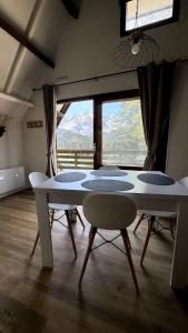 a room with a table and chairs and a large window at Chalet Le Capéna Lac de Payolle in Campan