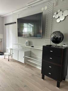 a living room with a dresser and a television on a wall at Apartment in beautiful area Edsviken, close to Stockholm in Sollentuna