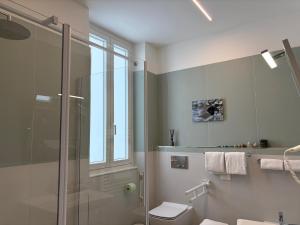 a bathroom with a glass shower and a toilet at Soleblu Guesthouse in Albissola Marina