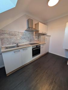 a kitchen with white cabinets and a sink at FeWo Luzia in Losheim