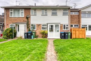 una casa con dos cubos de basura en el patio en Near Warwick Hospital, Cozy Studio, Free Parking, en Warwick