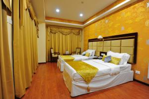 two beds in a hotel room with yellow walls at 33 Soksoom Centre for Well-Being & Happinesss - Boutique Hotel in Thimphu +39 photos