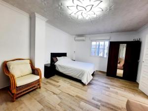 a bedroom with a bed and a chair and a chandelier at Casa Villami, GROUND FLOOR APARTMENT in Marchuquera +56 photos