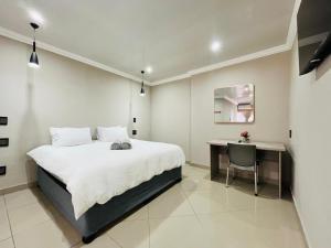 a bedroom with a bed and a desk in it at New Bali Guesthouse in Newcastle