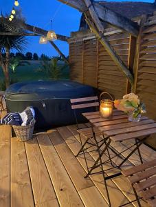 a patio with a hot tub and a picnic table at Bastide Blanche in Meigné-le-Vicomte