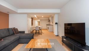 ein Wohnzimmer mit Couch und Flachbildfernseher in der Unterkunft MyHouseSpain - Edificio Vanguardia in Gijón