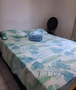 a bed with a colorful comforter on it at Apartamento acolhedor Maracanaú -Premium in Maracanaú