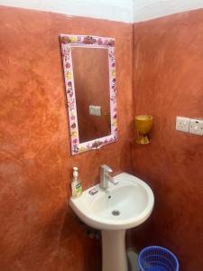 a bathroom with a sink and a mirror at Mufassa Beach Hotel in Jambiani