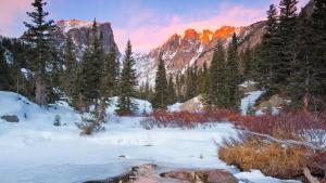 a snow covered field with trees and mountains at Luxury 2BR Mountain Townhouse w Picturesque Views in Silverthorne