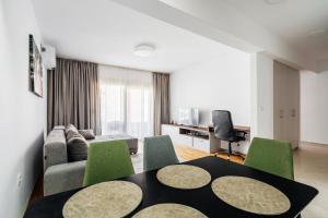 a living room with a table and green chairs at Status-M Apartments 187 in Becici