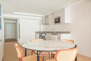 eine Küche mit Tisch und Stühlen in einem Zimmer in der Unterkunft MyHouseSpain - Edificio Vanguardia in Gijón + 38 Fotos
