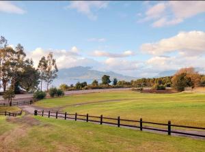 a fence in a field with mountains in the background at Cabañas Bellavista C1 in Puerto Varas