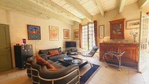 a living room with a couch and a table at Maison de Village en Camargue Parking Clim Wifi - ROSSIconciergerie - Linge inclus in Saint-Laurent-dʼAigouze