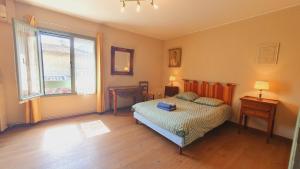 a bedroom with a bed and a window at Maison de Village en Camargue Parking Clim Wifi - ROSSIconciergerie - Linge inclus in Saint-Laurent-dʼAigouze