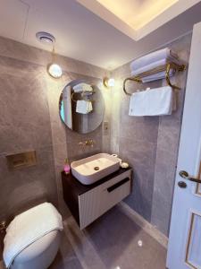 イスタンブールにあるSultan Suites Hotelの洗面台、トイレ、鏡のあるバスルーム