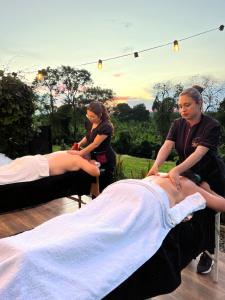 a woman is getting a woman on a bed at Persea Hospedaje in Armenia