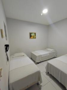 ゴイアニアにあるShopping 44 Hotelの白い壁の部屋にベッドが2つある