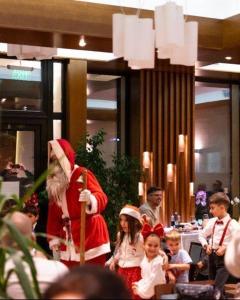een man verkleed als kerstman in een restaurant met kinderen bij Hotel Buchenland in Gura Humorului