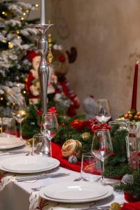 een kersttafel met wijnglazen en een kerstboom bij Hotel Buchenland in Gura Humorului