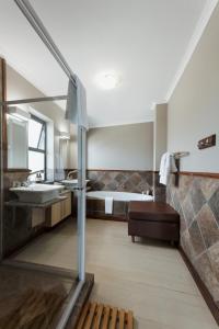 a bathroom with a sink and a bed at Whale Away Guest House in Hermanus