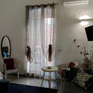 a living room with a table in front of a window at Principe Umberto in Parabita