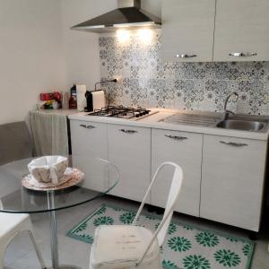 a kitchen with a glass table and a sink at Principe Umberto in Parabita