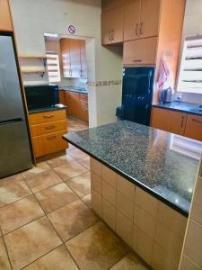 a kitchen with wooden cabinets and a counter top at Tau Golden Mane in Johannesburg