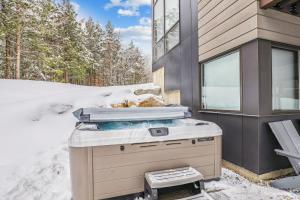 un gril dans la neige à côté d'une maison dans l'établissement Natures Way: 4 br, fireplace, a/c, hot tub, community summer pool, garage, à Stowe Fork