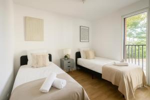 zwei Betten in einem Zimmer mit Balkon in der Unterkunft Spacieux 3 chambres et lumineux à Montrouge in Malakoff