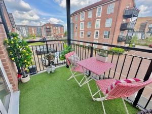 Un balcón con una mesa y sillas en un balcón. en Pink Paradise, en Dunstable