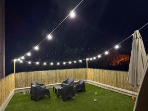 eine Terrasse mit Stühlen und Lichtern bei Nacht in der Unterkunft Charmante maison rénovée avec terrasse et jardin in Crillat + 14 Fotos