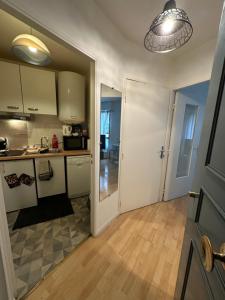 a kitchen with white cabinets and a door to a room at Charmant studio à Paris in Courbevoie