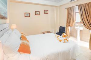 a bedroom with a white bed and a sink at Family Getaway Suite at Hummingbird Home Suites Gold Standard Certified in San Pedro +13 photos