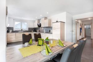 una cocina con una mesa de madera con servilletas verdes encima en Haus Haldenweg, en Höchenschwand