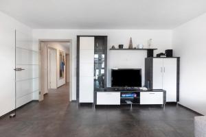 sala de estar con mesa y TV en Haus Haldenweg, en Höchenschwand