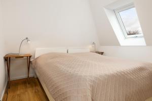 une chambre blanche avec un lit et une fenêtre dans l'établissement Dock 53, à Heikendorf