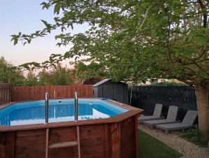 a swimming pool in a backyard with chairs and a tree at Loft in Brizambourg